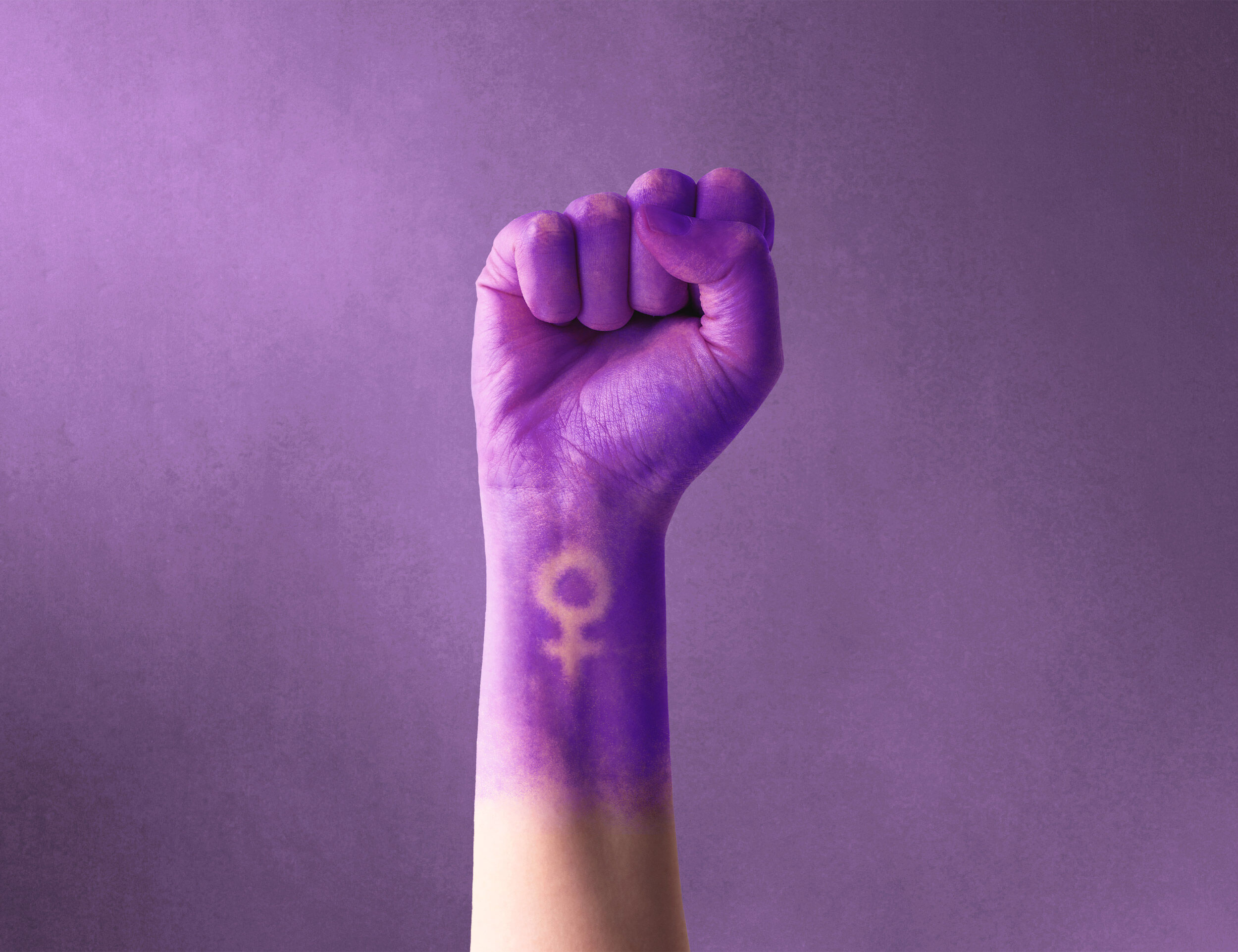women coloured her hand purple and made symbol for strength and courage of womens