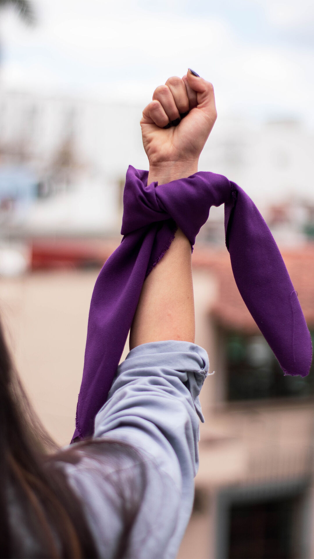women wearing purple scarf on her hand as symbol of justice 