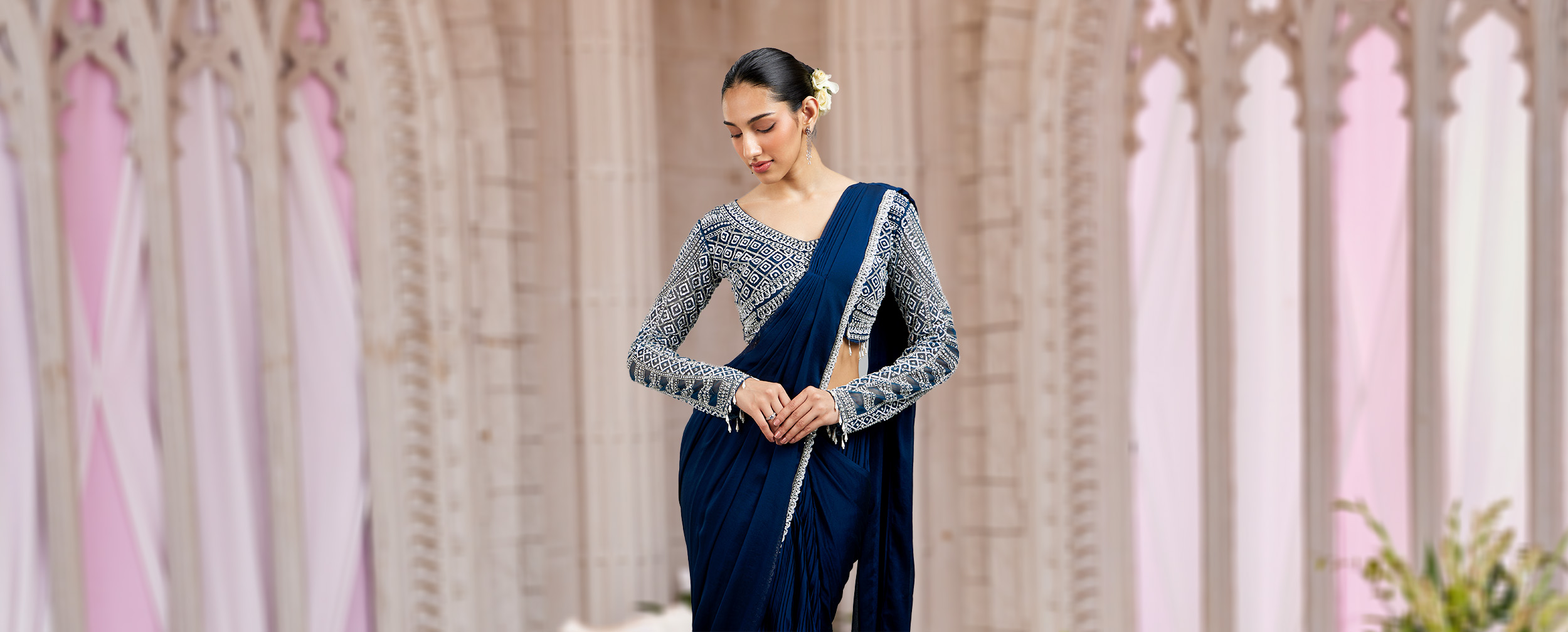 Woman wearing blue saree in a stylish contemporary pose Woman wearing blue saree in a stylish contemporary pose