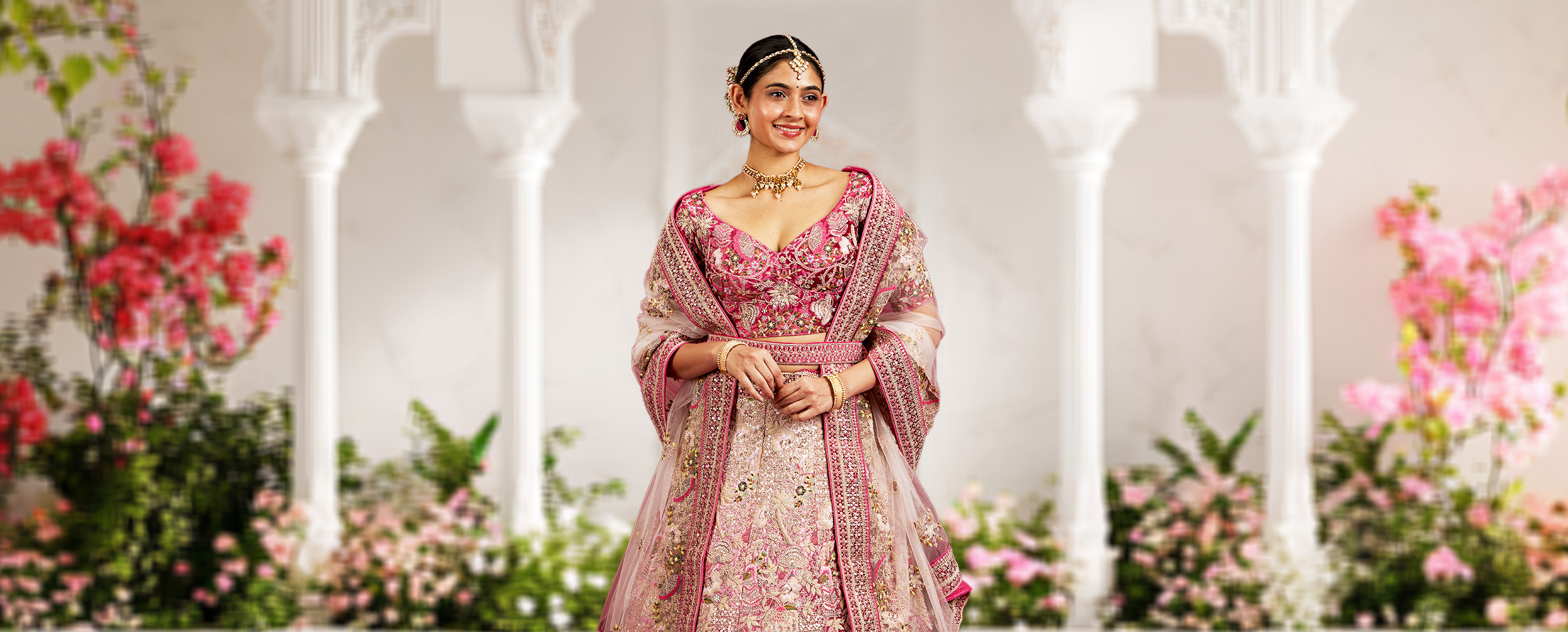 Woman wearing a Muted Pink Lehenga with modern style matching blouse Woman wearing a Muted Pink Lehenga with modern style matching blouse