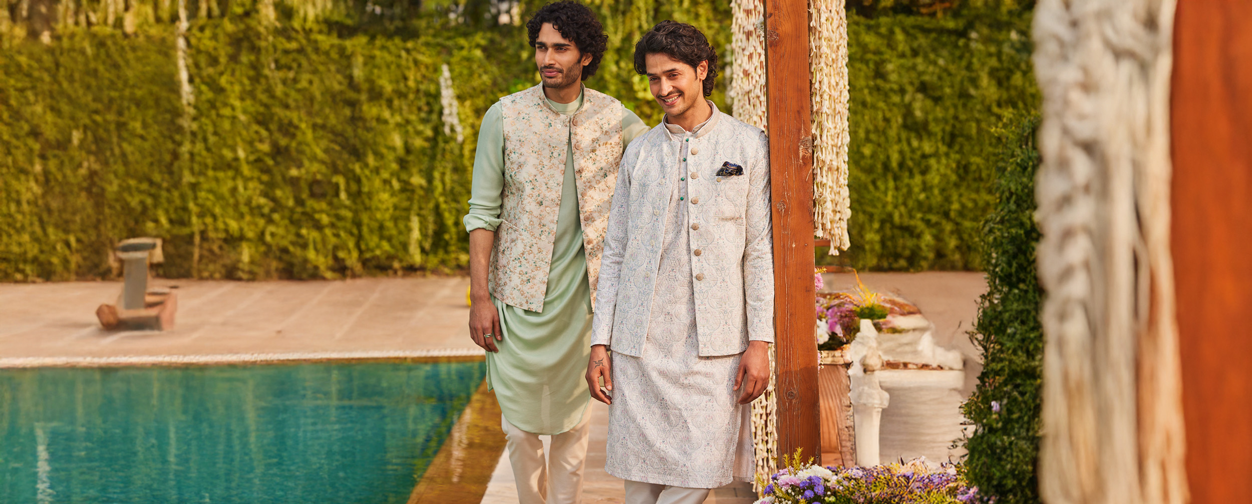 Stylishly dressed men in designer kurta pajama sets with floral and embroidered Nehru jackets—perfect festive and wedding outfit inspiration for men.