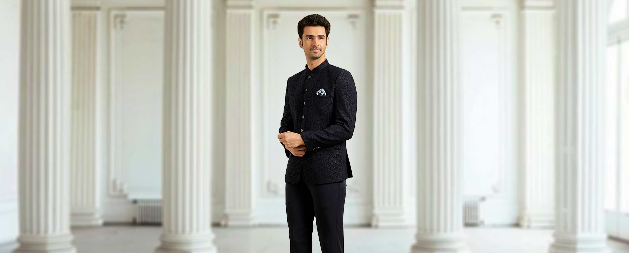 Man in a black patterned Jodhpuri suit with a Bandhgala collar, perfect for wedding receptions. Man in a black patterned Jodhpuri suit with a Bandhgala collar, perfect for wedding receptions.