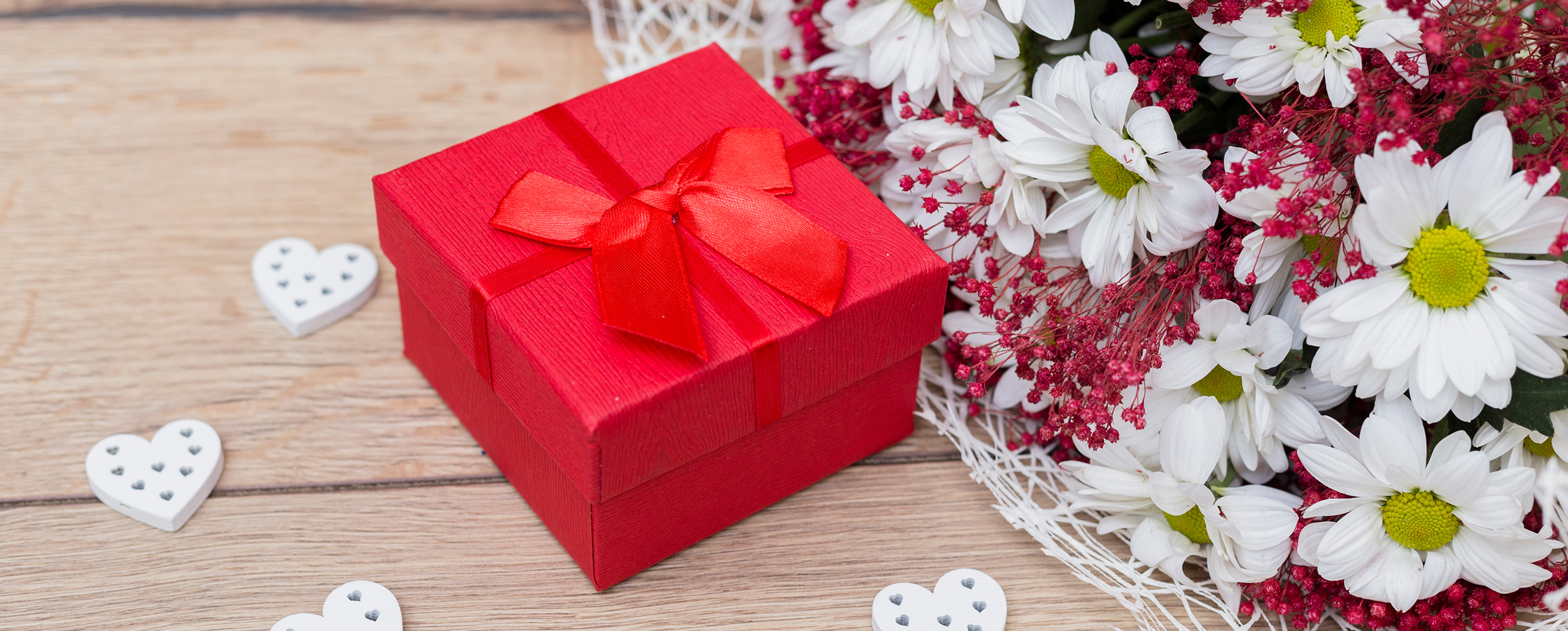 red gift box with flowers around red gift box with flowers around