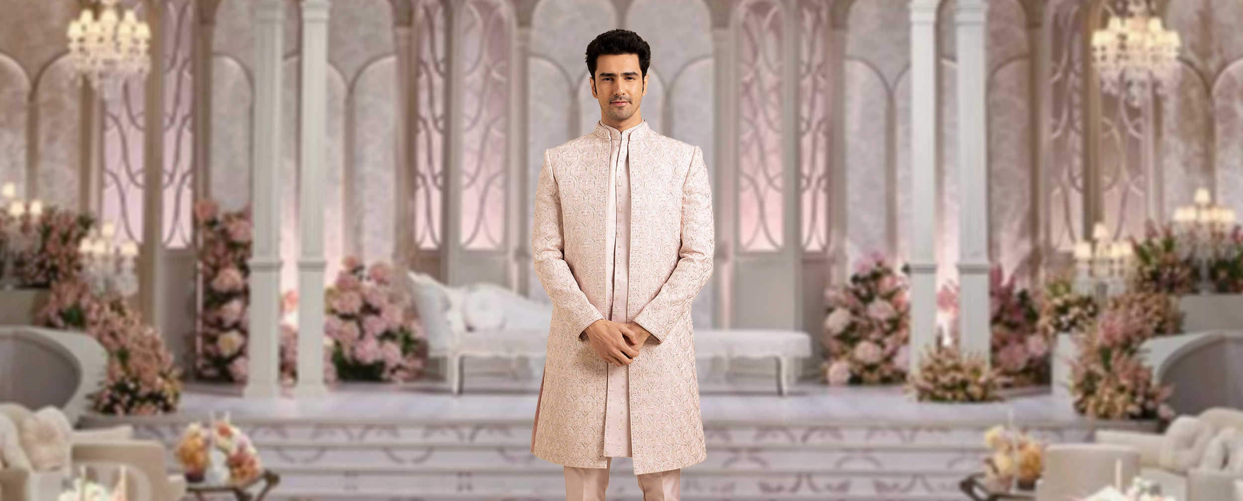  Man in a blush pink embroidered long sherwani and straight trousers, ideal for a wedding look.