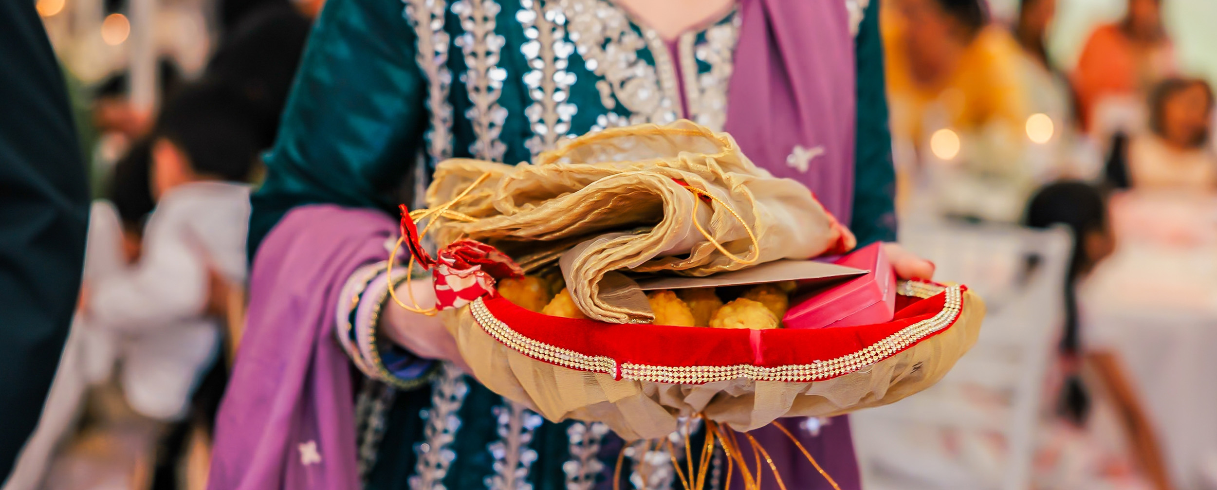 Loving grandmother holding a gift katori filled with a saree, laddoo, and a gift box, a heartfelt wedding gift for her grandson and his bride. Loving grandmother holding a gift katori filled with a saree, laddoo, and a gift box, a heartfelt wedding gift for her grandson and his bride.