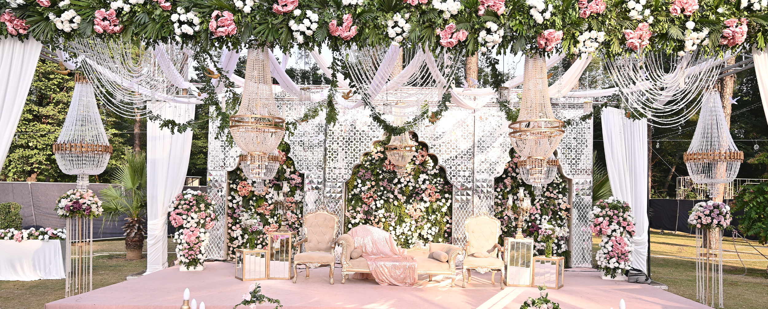 Vibrant mehendi decoration with a stunning white-themed backdrop and floral arrangements. Vibrant mehendi decoration with a stunning white-themed backdrop and floral arrangements.