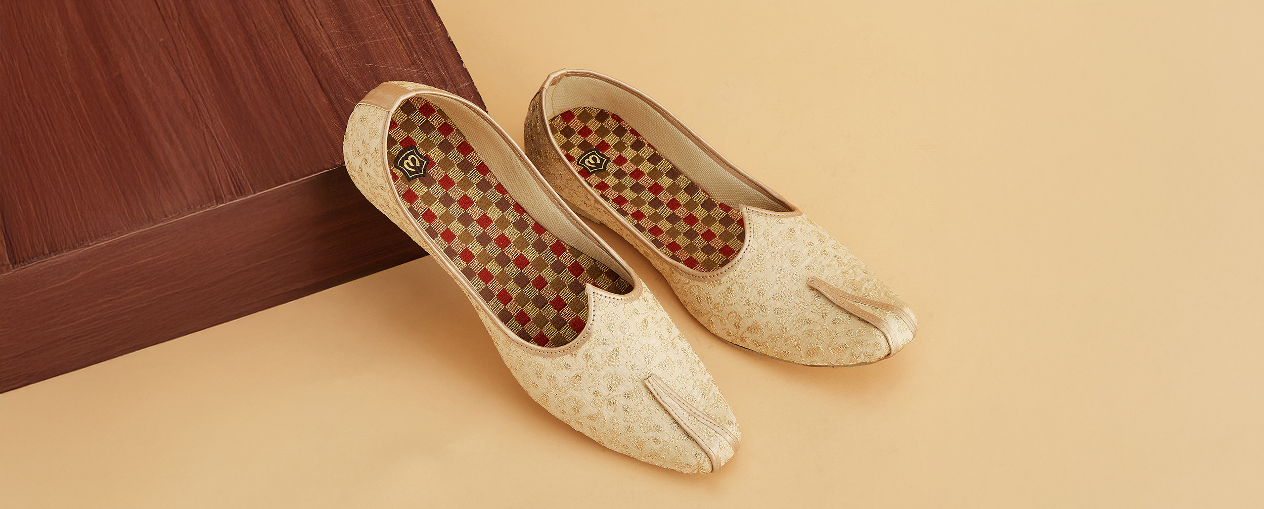 Pair of gold embroidered Juti (Indian shoes) with patterned insoles.