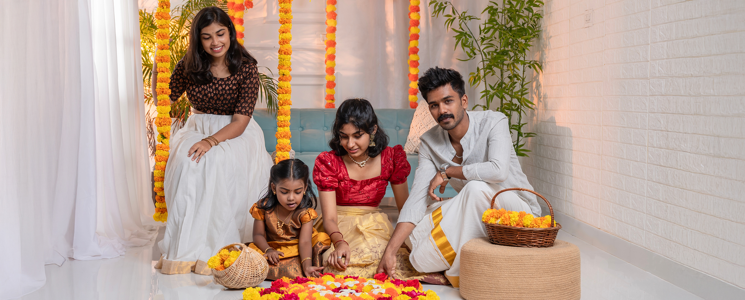 Family in traditional Kerala Onam outfits, including kasavu-inspired white and gold attire, celebrating with a pookalam.