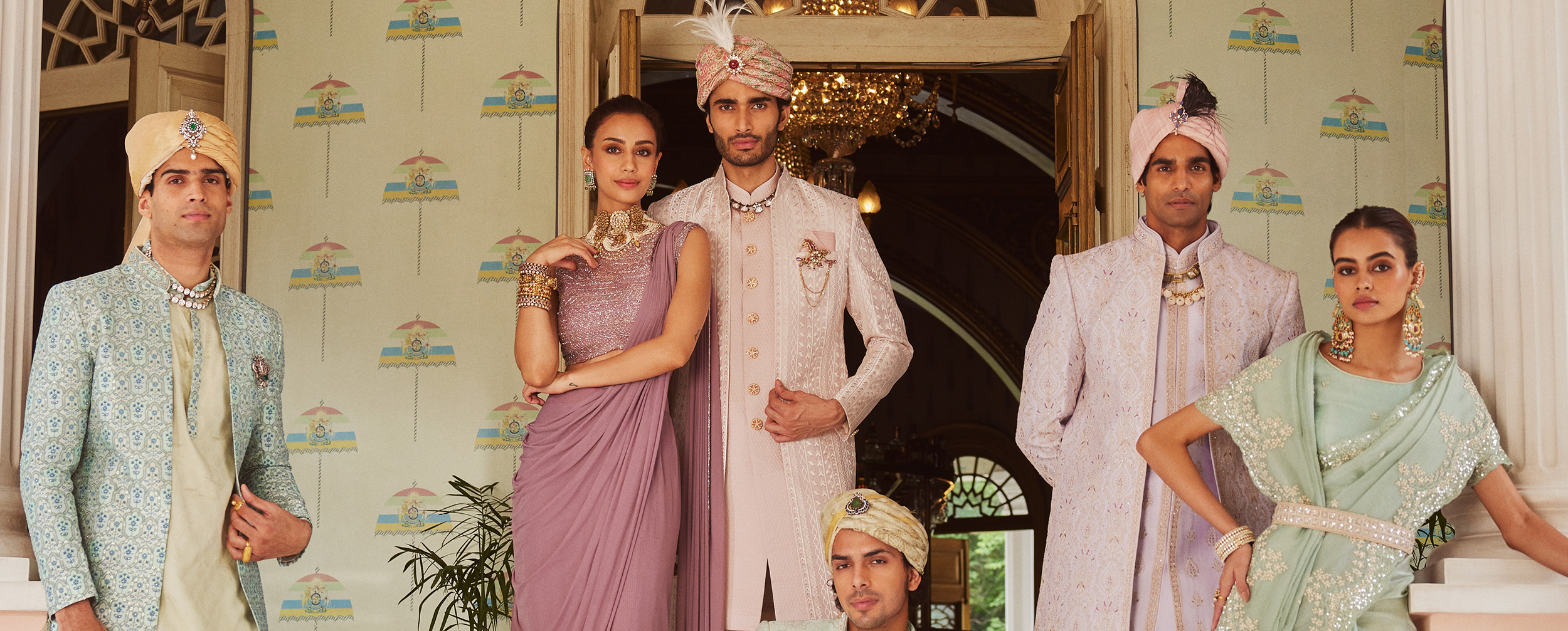 Group of models showcasing men's sherwanis and contrasting safas (turbans) with coordinated traditional jewelry.