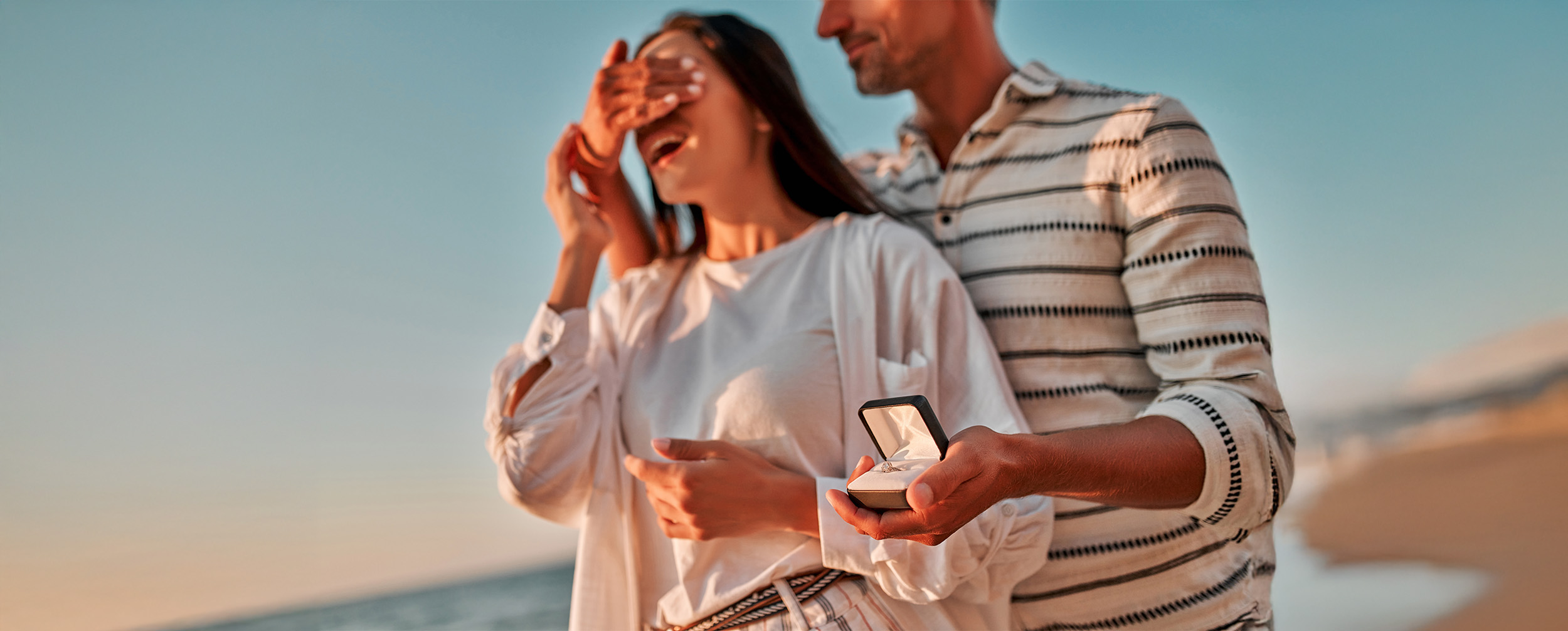 A man proposing a girl from behind with ring in his hand A man proposing a girl from behind with ring in his hand