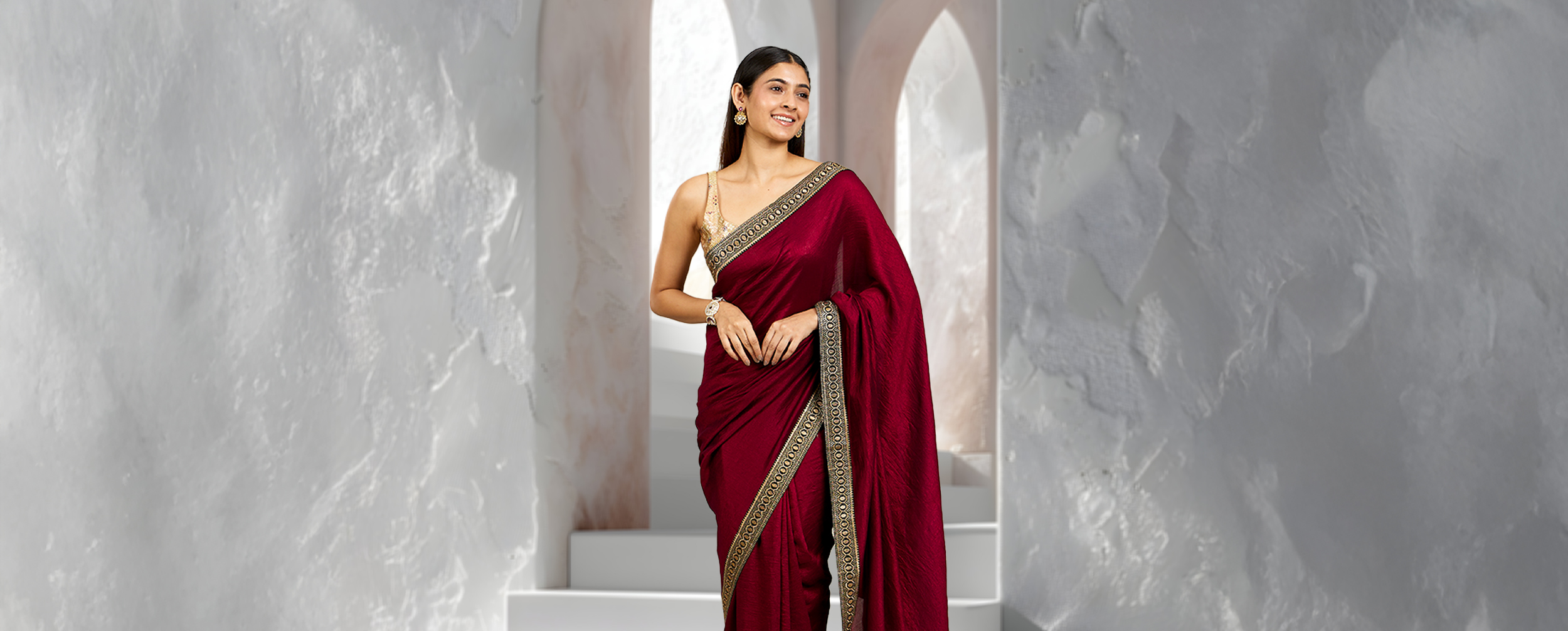 Woman wearing modern red silk saree with innovative draping style Woman wearing modern red silk saree with innovative draping style
