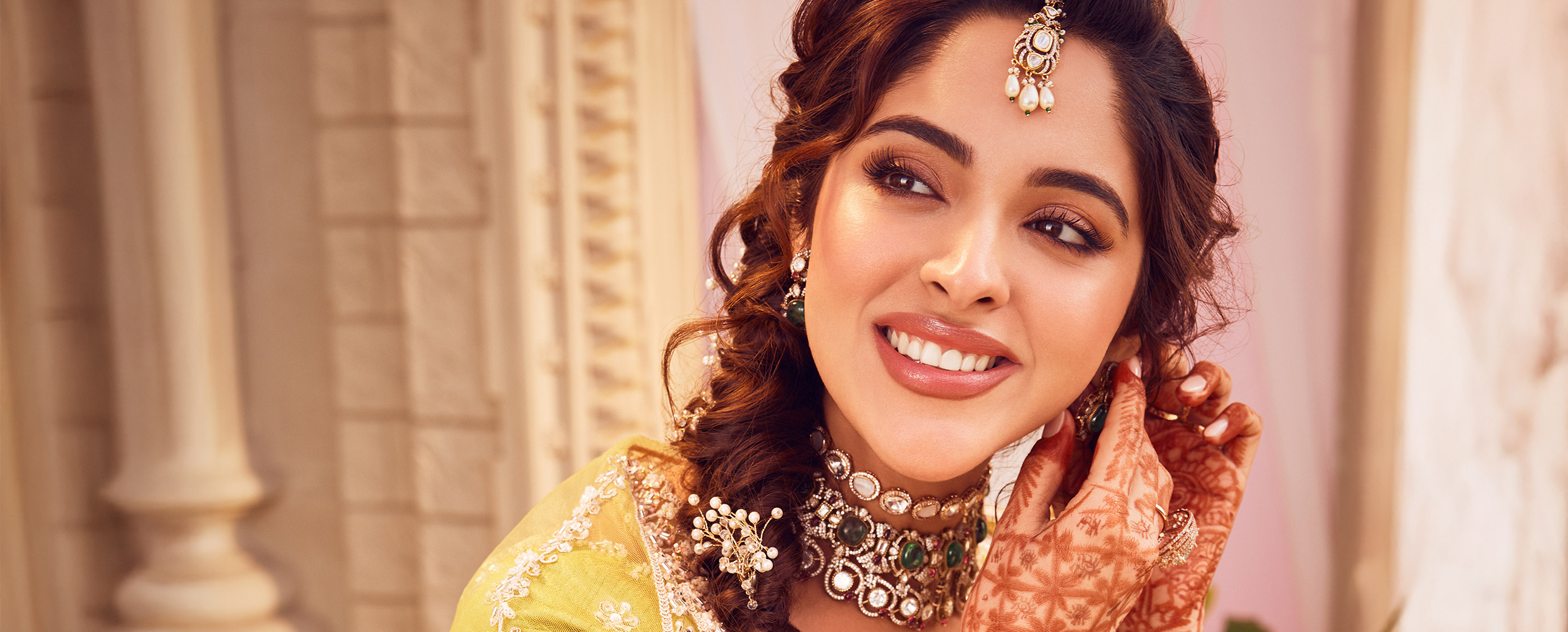 Indian bride in yellow lehenga and gold jewellery flaunting her beautiful earrings. Indian bride in yellow lehenga and gold jewellery flaunting her beautiful earrings.