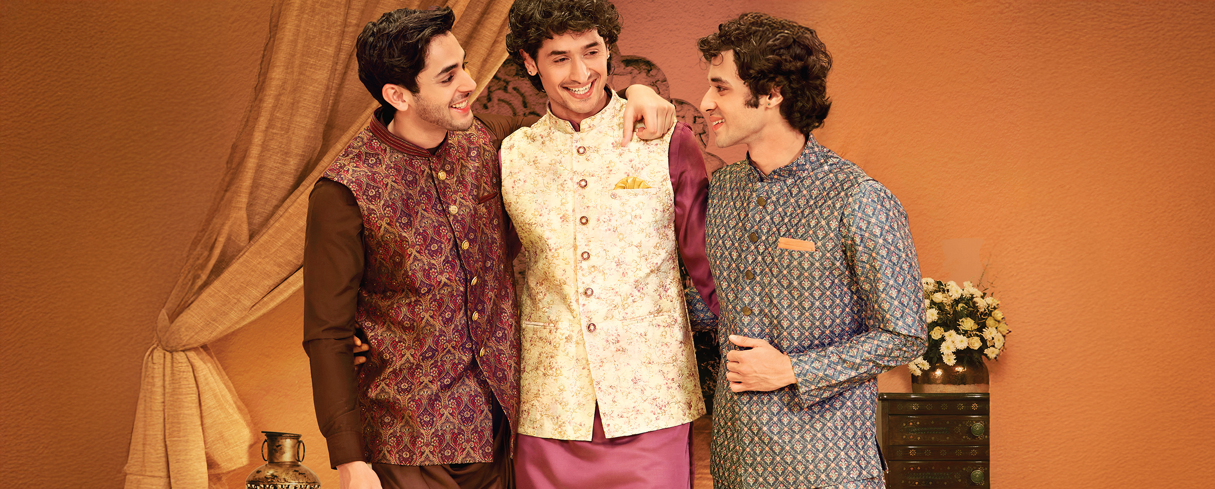 Three men in vibrant designer kurta pajama sets with Nehru jackets, celebrating in stylish wedding outfits Three men in vibrant designer kurta pajama sets with Nehru jackets, celebrating in stylish wedding outfits