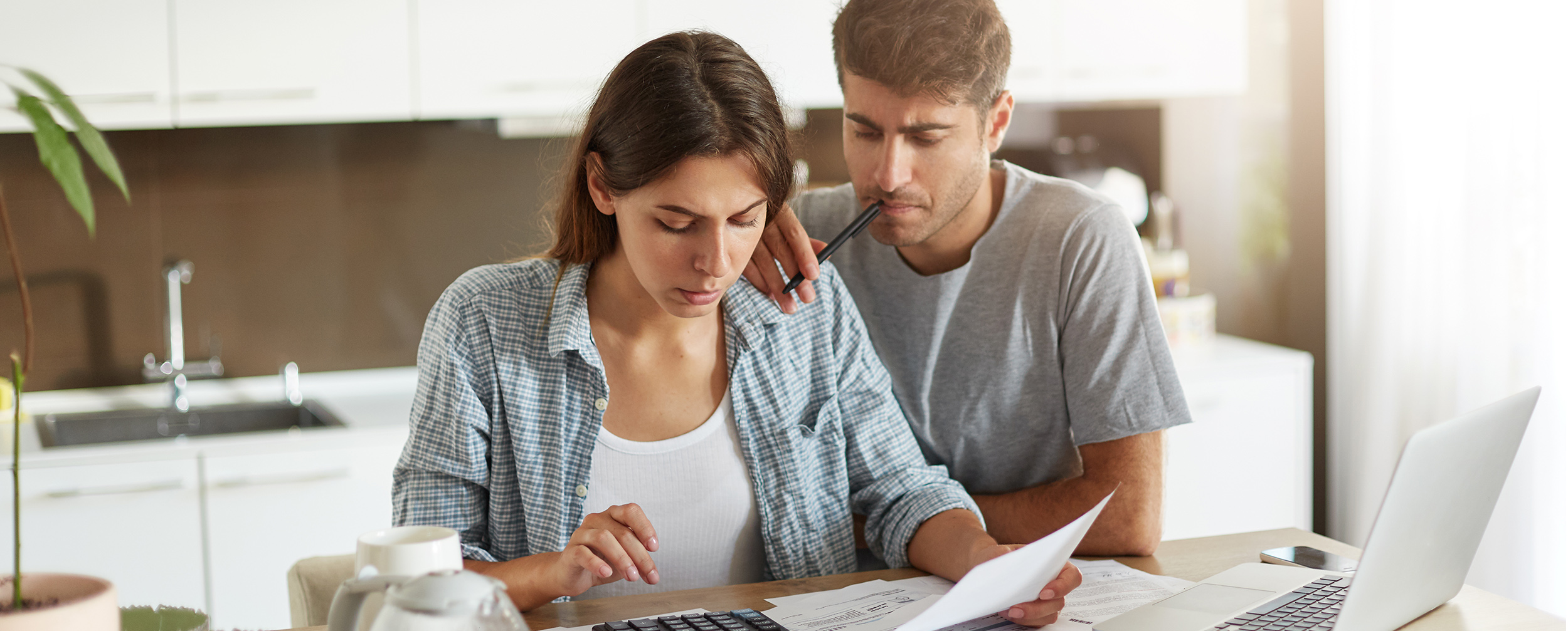 Bride and groom discussing their wedding budget with a planner and notes