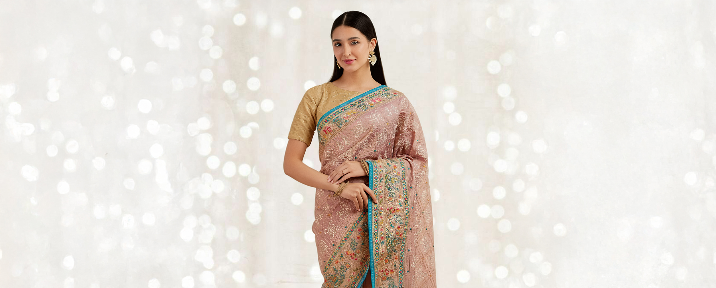 A woman wearing a beautiful embroidered pink saree for a festive Diwali celebration.